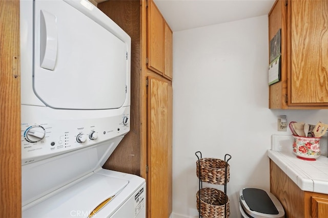 laundry area featuring cabinet space and stacked washer and clothes dryer