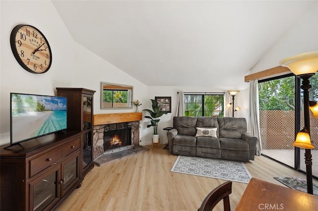 living area with light wood finished floors, a fireplace, and lofted ceiling