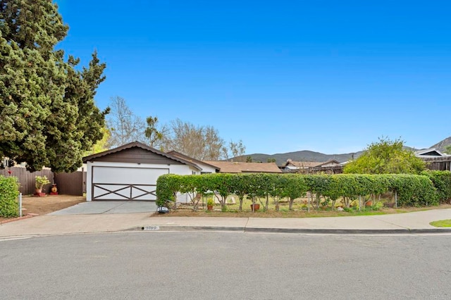 view of front of house featuring concrete driveway, a garage, and fence