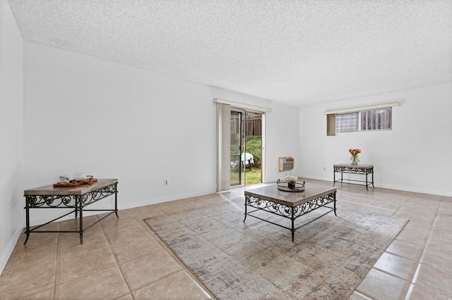 living area with tile patterned floors, a textured ceiling, and baseboards