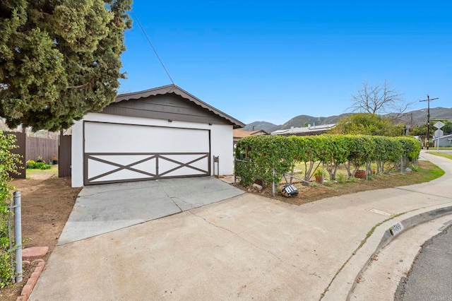 garage featuring a mountain view and fence