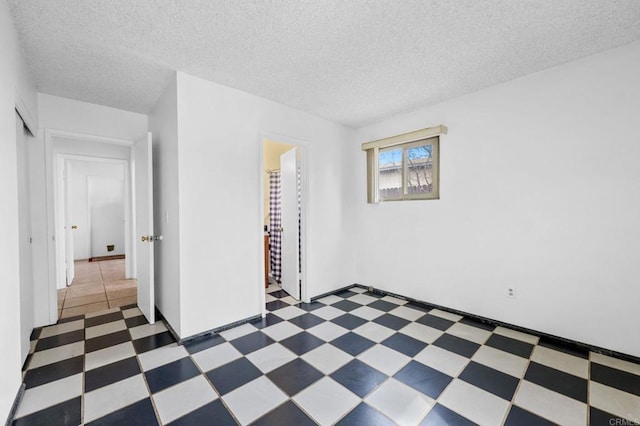 empty room featuring tile patterned floors and a textured ceiling