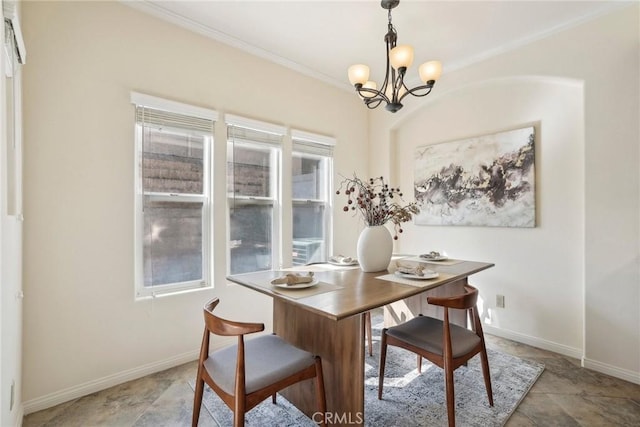 dining space featuring an inviting chandelier, baseboards, and ornamental molding