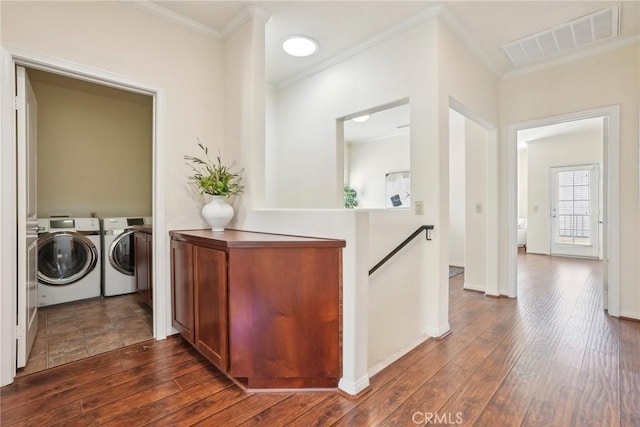 interior space featuring washer and dryer, dark wood-type flooring, an upstairs landing, and visible vents