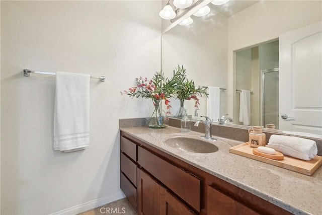 bathroom featuring a stall shower, vanity, and baseboards