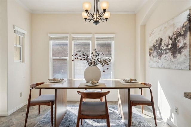 dining area with baseboards, a chandelier, and crown molding