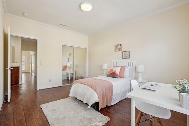 bedroom featuring visible vents, ornamental molding, dark wood-style floors, a closet, and baseboards