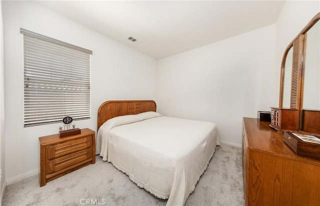 bedroom with visible vents, light colored carpet, and baseboards