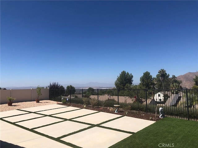 view of patio / terrace with a mountain view and fence