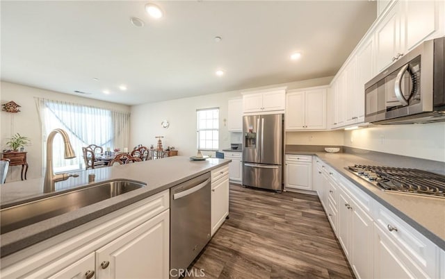 kitchen featuring dark wood-type flooring, recessed lighting, appliances with stainless steel finishes, white cabinets, and a sink