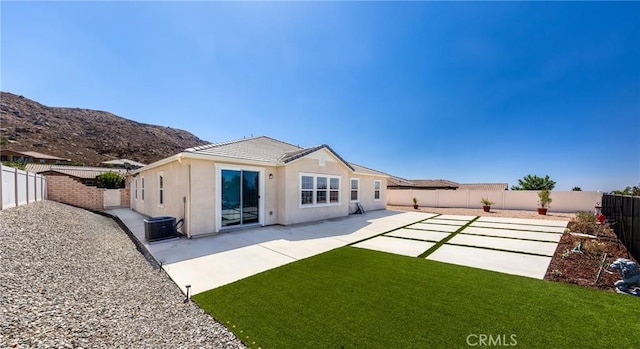 back of house featuring a patio area, central AC unit, a fenced backyard, and stucco siding