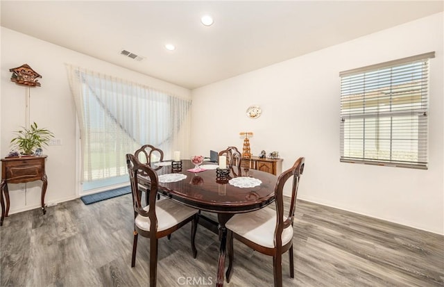 dining space featuring wood finished floors, visible vents, and baseboards