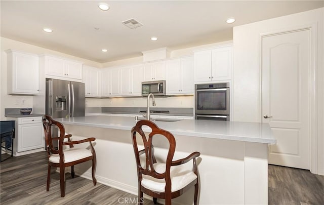 kitchen featuring dark wood finished floors, visible vents, white cabinetry, and stainless steel appliances