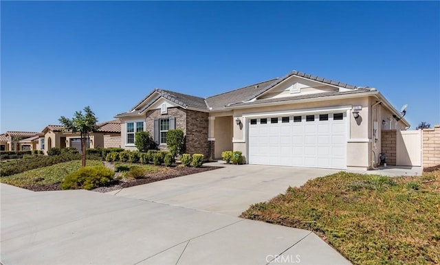 ranch-style home with stucco siding, driveway, fence, a garage, and brick siding