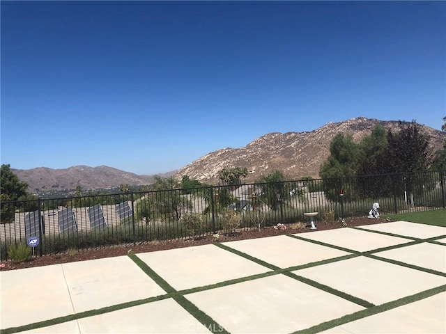 view of patio with fence and a mountain view