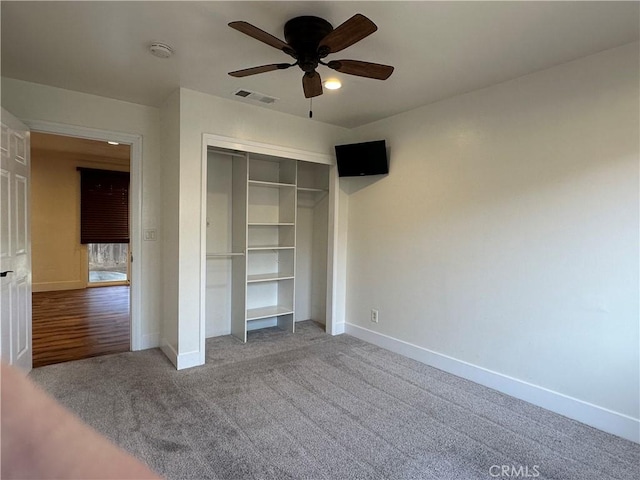 unfurnished bedroom featuring baseboards, visible vents, ceiling fan, a closet, and carpet flooring