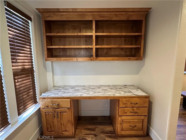 office with baseboards and built in desk