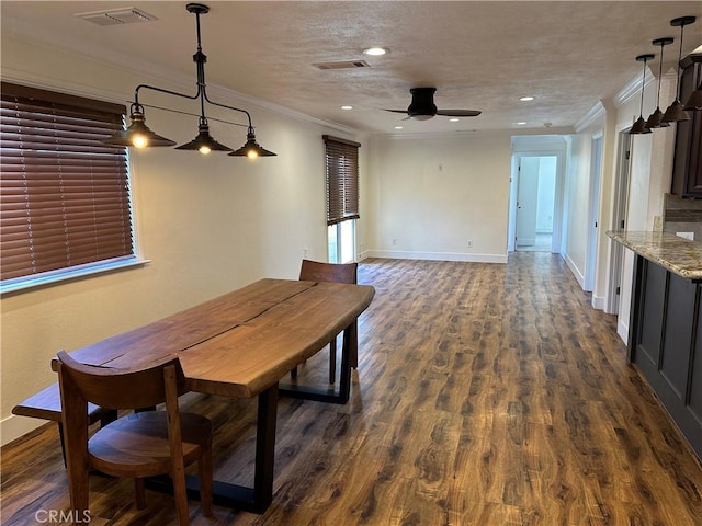 dining space with visible vents, a textured ceiling, ornamental molding, and dark wood-style flooring