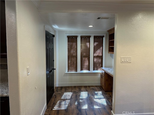 hallway featuring dark wood finished floors and baseboards