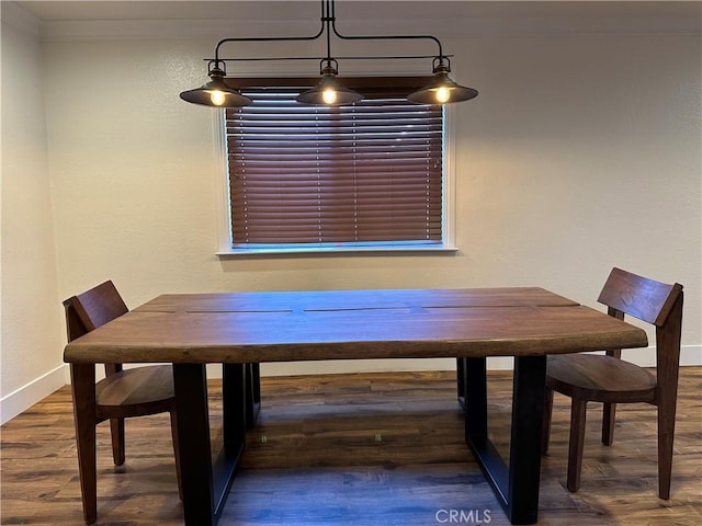 unfurnished dining area featuring baseboards and wood finished floors