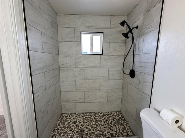 bathroom featuring toilet and tiled shower