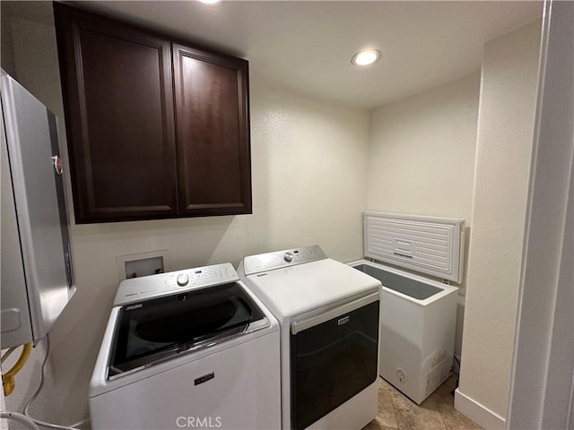 laundry room with cabinet space, washer and dryer, and baseboards