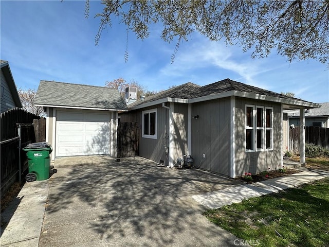 ranch-style house featuring fence, central air condition unit, concrete driveway, a garage, and an outdoor structure