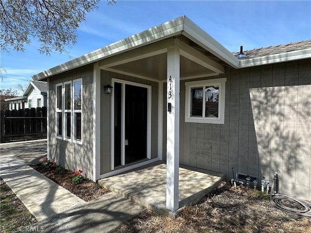 entrance to property featuring a patio area and fence