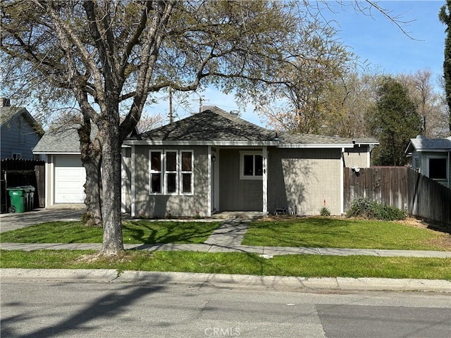 view of front facade with a garage, driveway, a front yard, and fence