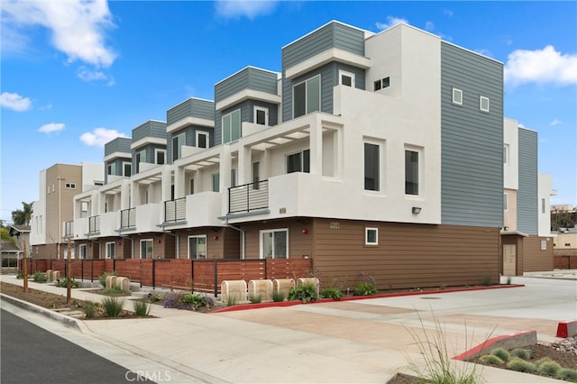 view of building exterior featuring fence and a residential view