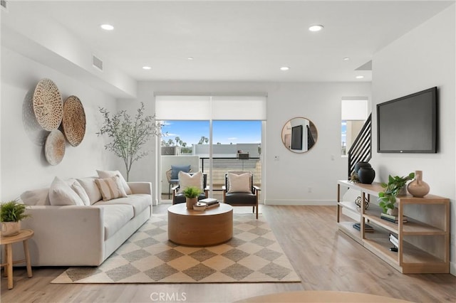 living area with recessed lighting, light wood-type flooring, baseboards, and visible vents