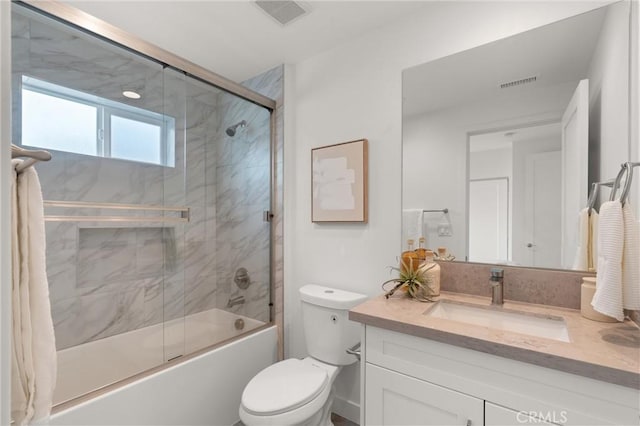 bathroom with vanity, toilet, visible vents, and combined bath / shower with glass door