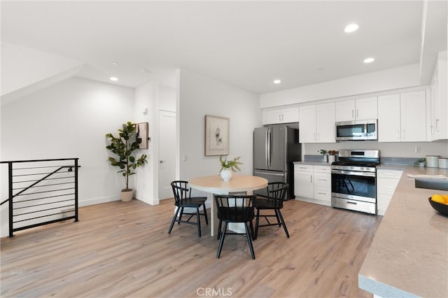 kitchen featuring recessed lighting, appliances with stainless steel finishes, light wood-style flooring, and white cabinetry