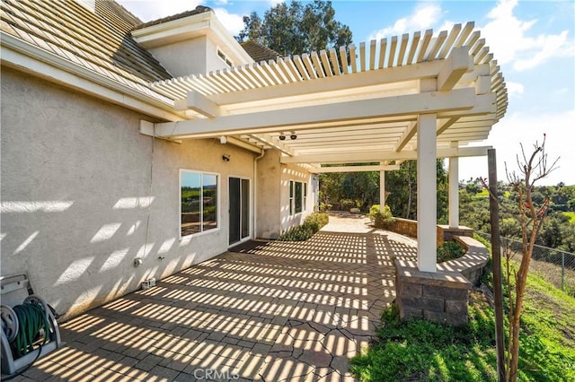 view of patio with a pergola and fence