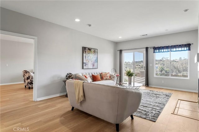 living room with visible vents, recessed lighting, light wood-style floors, and baseboards