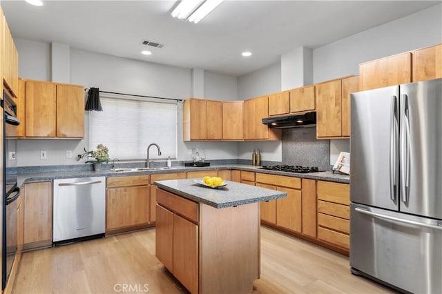 kitchen with visible vents, under cabinet range hood, a sink, stainless steel appliances, and light wood-style floors