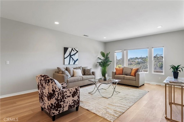 living room featuring light wood finished floors, visible vents, recessed lighting, and baseboards