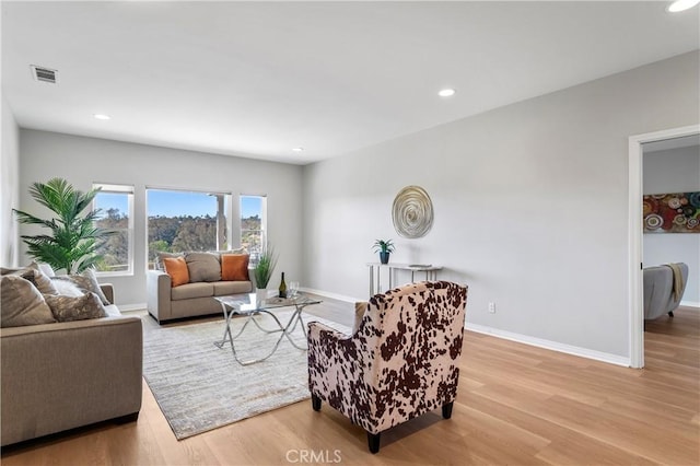 living area with recessed lighting, visible vents, baseboards, and light wood-style floors