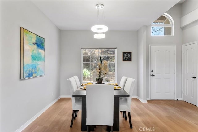 dining room with baseboards and light wood finished floors