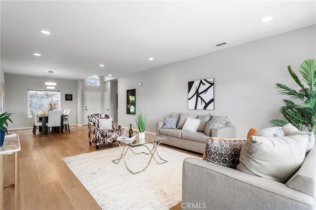 living area with recessed lighting, visible vents, baseboards, and light wood-style flooring