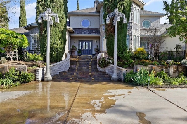 exterior space with stucco siding and french doors