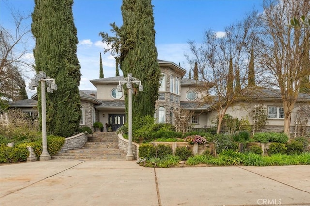 view of front of property featuring stucco siding and stone siding