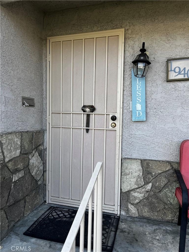 property entrance with stucco siding