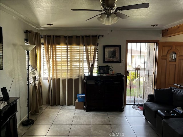 living room with light tile patterned floors, a textured ceiling, and a ceiling fan