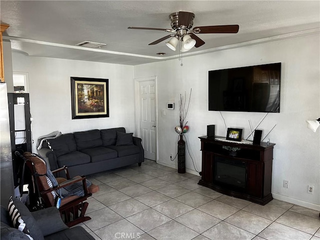 living area featuring light tile patterned floors, a ceiling fan, visible vents, and baseboards