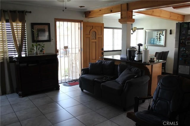 living area featuring ceiling fan, lofted ceiling with beams, and light tile patterned flooring