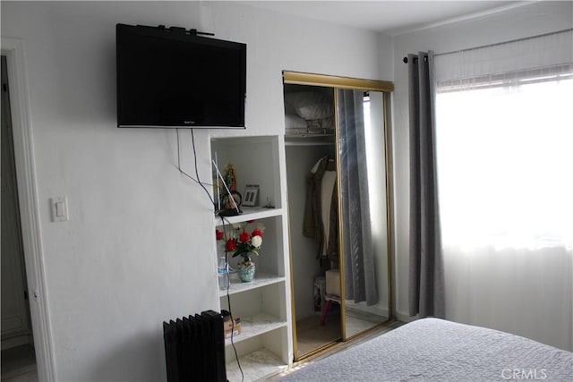 bedroom with a closet and radiator heating unit