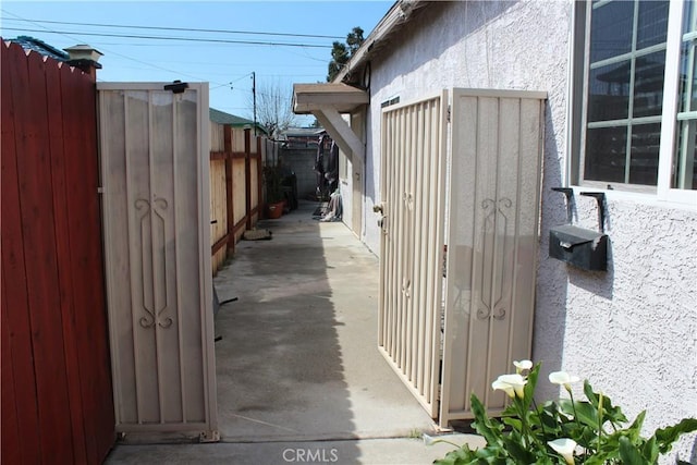 view of side of property with fence and stucco siding