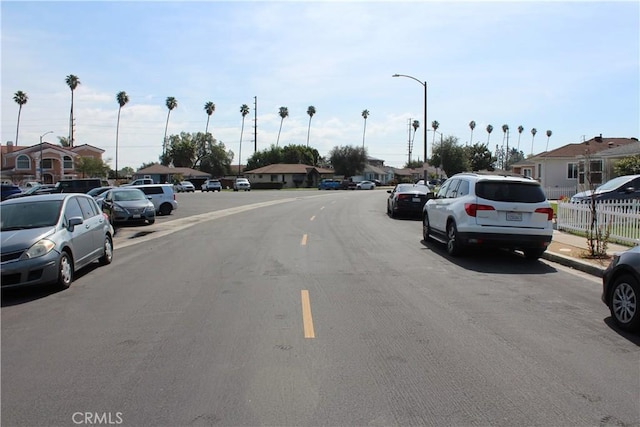 view of road featuring a residential view, street lights, and sidewalks