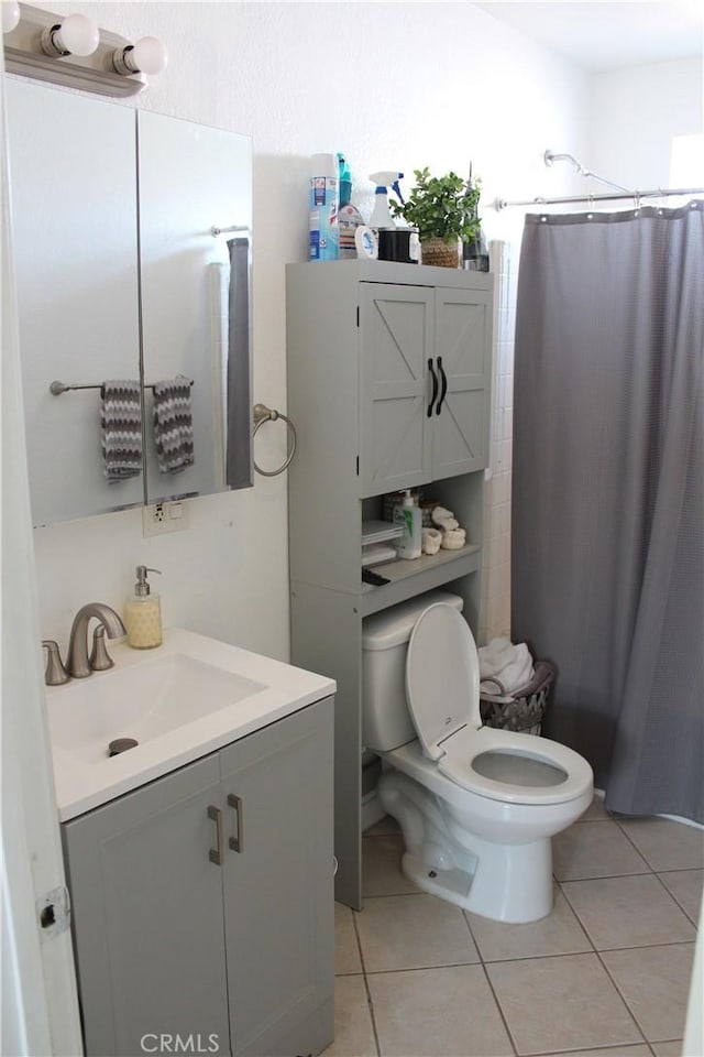 bathroom with tile patterned floors, toilet, vanity, and a shower with curtain